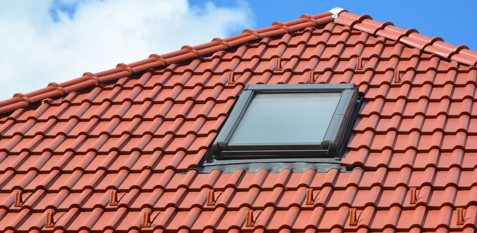 light brown tile roofing of a house with a window in the middle